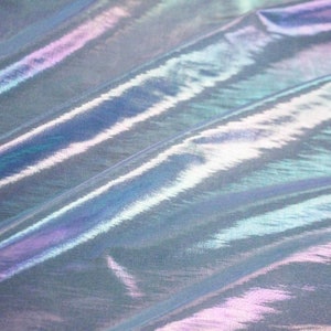May include: Iridescent fabric with a shimmering, multi-colored effect. The fabric has a smooth texture and reflects light, creating a play of blues, purples, and greens. The material is draped, showing folds and subtle shadows.