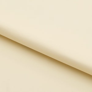 Pu&ograve; includere: Primo piano di una superficie liscia di colore avorio con una piega diagonale sottile. La superficie &egrave; illuminata uniformemente e sembra essere fatta di un materiale morbido e flessibile.