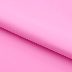 Pu&ograve; includere: Un foglio di carta rosa pieno piegato a met&agrave;, creando una piega diagonale.