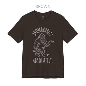 Abominable? Absolutely Yeti Tee | Funny Bigfoot Shirt | Cryptid Top | Unisex Jersey Tee Brown
