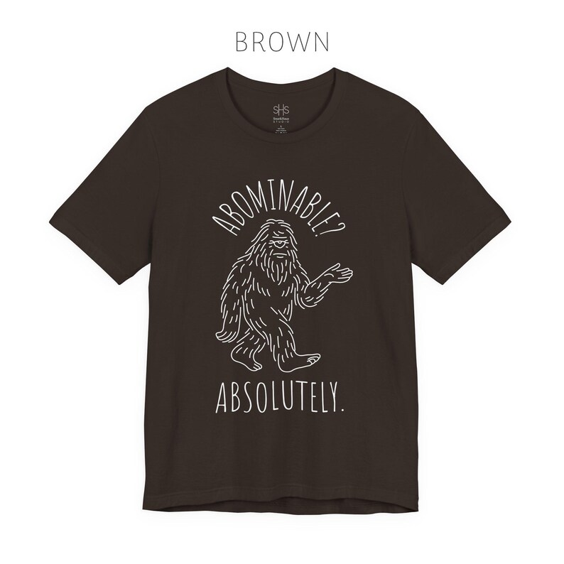 Abominable? Absolutely Yeti Tee | Funny Bigfoot Shirt | Cryptid Top | Unisex Jersey Tee Brown
