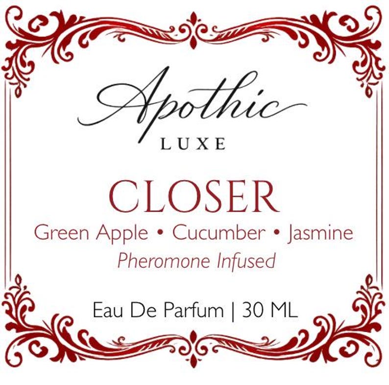 K&ouml;nnte beinhalten: Ein wei&szlig;es Etikett mit burgunderfarbenen Zierbl&uuml;ten und Text. Das Etikett lautet "Apothic LUXE CLOSER" mit Duftnoten von gr&uuml;nem Apfel, Gurke und Jasmin. Es ist ein Pheromon-infundiertes Eau De Parfum, 30 ml.