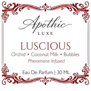 Puede incluir: Etiqueta Apothic Luxe Luscious Eau De Parfum. La etiqueta presenta un borde burdeos decorativo y texto. El texto incluye "Luscious", "Orchid, Coconut Milk, Bubbles" y "Pheromone Infused". El frasco contiene 30 ml.