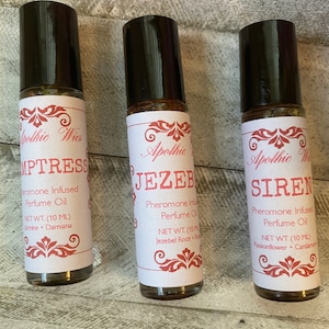 May include: Three small glass bottles with black roll-on tops and white labels. The labels have red and gold accents and feature the text "Apothic Wies" and the names "Mistress", "Jezebel", and "Siren". Each bottle contains a pheromone infused perfume oil with a net weight of 10 ml.