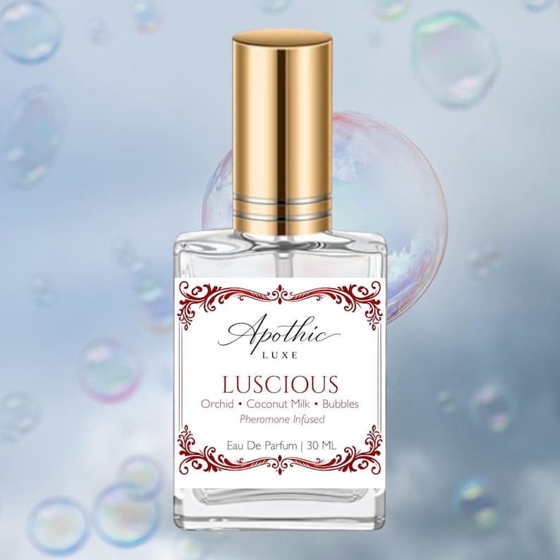 Puede incluir: Un frasco de perfume transparente con tapa dorada. La etiqueta dice "Apothic Luxe LUSCIOUS" con las notas de fragancia: Orqu&iacute;dea, Leche de coco, Burbujas e Infusi&oacute;n de feromonas. El frasco contiene 30 ml de Eau De Parfum.
