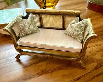 Sofá Duncan Phyphe vintage azul con respaldo de caña, en miniatura para casa de muñecas, con detalles en dorado regio y asiento tipo banco color crema. Escala 1:12. Tapicería.