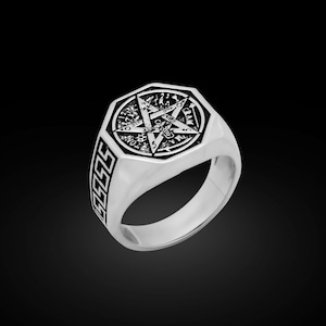 Könnte beinhalten: Ein silberfarbener Ring mit einem Pentagramm-Design. Der Ring hat eine achteckige Oberfläche mit einem detaillierten Stern und Symbolen. Das Band weist ein sich wiederholendes geometrisches Muster auf. Der Ring ist vor schwarzem Hintergrund platziert.