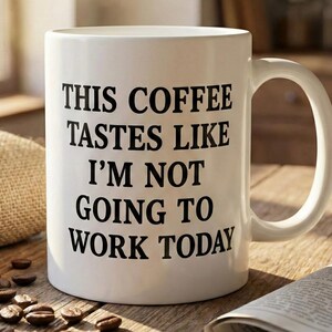 Pode incluir: Uma caneca de café de cerâmica branca com o texto "THIS COFFEE TASTES LIKE I'M NOT GOING TO WORK TODAY" em preto. A caneca está numa mesa de madeira com grãos de café e um jornal. Vapor sobe da caneca.