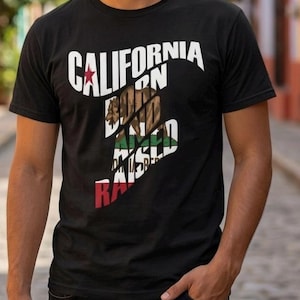 Op de afbeelding: Zwart t-shirt met de tekst "CALIFORNIA BORN RAISED" in wit, rood, groen en bruin. Het ontwerp bevat een ster en een beer, die de staat Californië vertegenwoordigen.