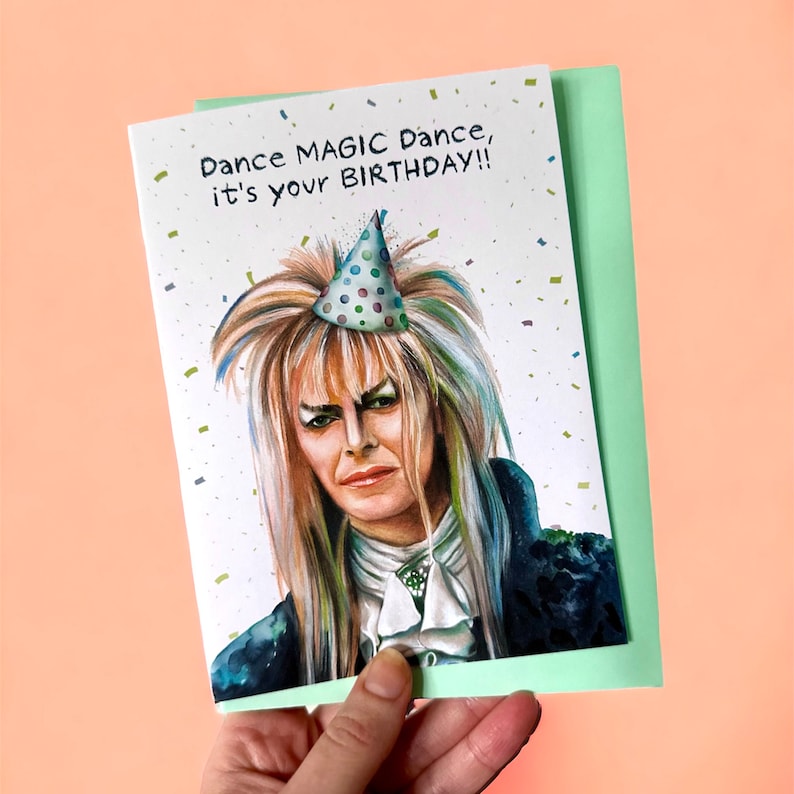 K&ouml;nnte beinhalten: Eine Geburtstagskarte mit einer Zeichnung eines Charakters mit langen, bunten Haaren, der einen Partyhut tr&auml;gt. Die Karte tr&auml;gt den Text "Dance MAGIC dance, it's your BIRTHDAY!!"