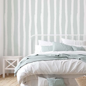 Watercolor striped wallpaper in pale green and white in peel and stick and traditional wallpaper. Renter friendly.