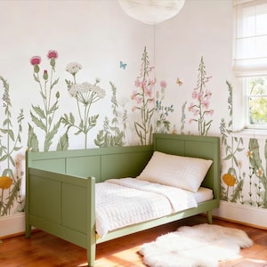 May include: A child's bedroom with a green bed, white bedding, and a fluffy white rug. The walls are decorated with a floral wallpaper featuring pink, white, and green wildflowers and butterflies. The room has a cozy and natural aesthetic.