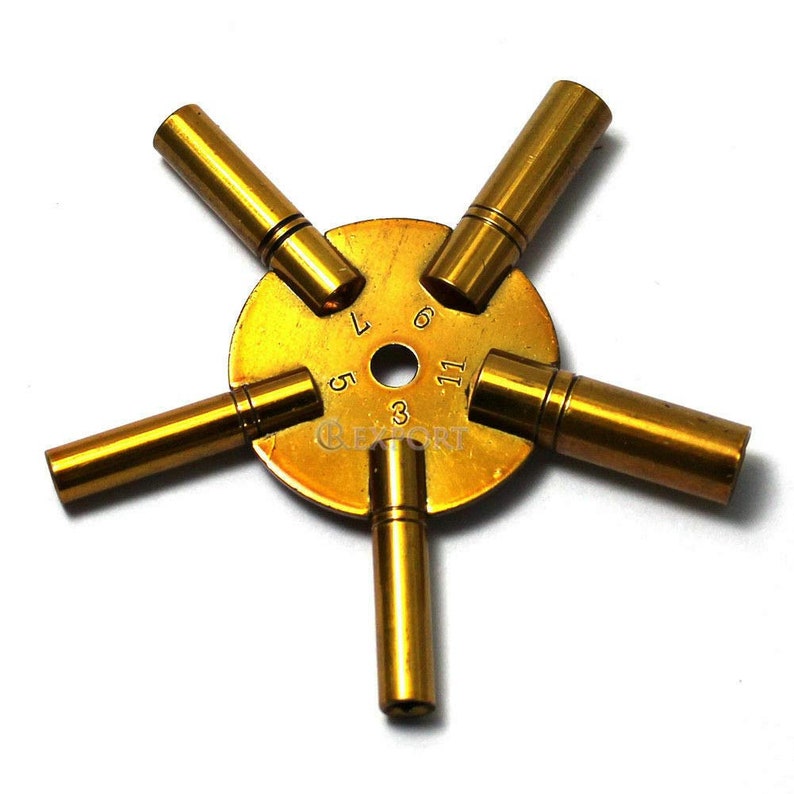 May include: A brass watch key winding tool with five different sized keys. The keys are numbered 3, 5, 7, 9, and 11.