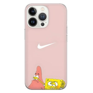 May include: Pink iPhone 13 Pro Max phone case featuring a white Nike swoosh logo.  The bottom of the case shows Patrick Star and SpongeBob SquarePants from SpongeBob Squarepants with their hands over their eyes. The case is made of clear, flexible plastic.