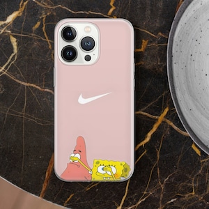 May include: Pink iPhone 12/13 Pro Max phone case featuring a white Nike swoosh logo and cartoon characters Patrick Star and SpongeBob SquarePants playfully covering their eyes. The case is made of clear, flexible plastic and shows off the phone's camera lenses.