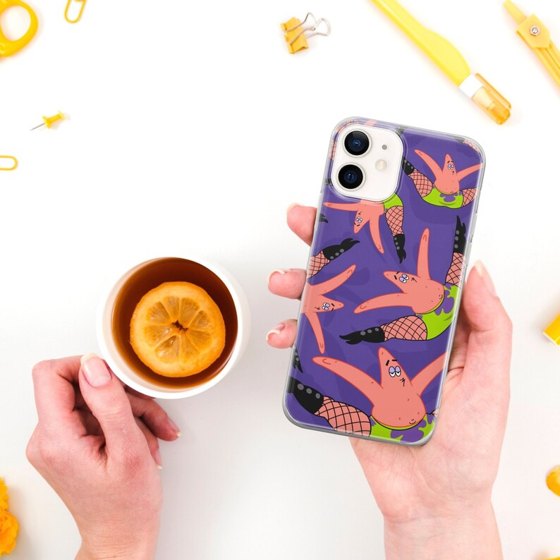 May include: Purple iPhone 13 phone case featuring a repeating pattern of Patrick Star from SpongeBob SquarePants wearing fishnet stockings and heels.  The case is clear and shows the phone's camera lenses. The design is vibrant and playful.