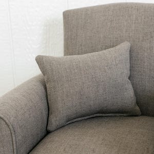 May include: A rectangular throw pillow made of a textured, taupe-colored fabric. The pillow features a simple, solid-colored design with visible woven threads, resting against the matching upholstered back and seat of a chair.