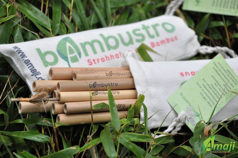 May include: A set of natural bamboo straws in a white canvas bag with the text "bambustro Strohhalme Bambus" printed on the bag. The straws are bundled together and are ready to be used.