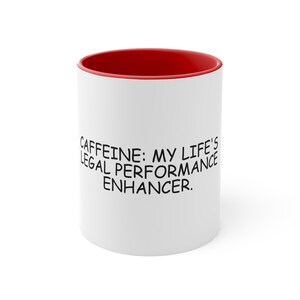 Może przedstawiać: Biały ceramiczny kubek do kawy z czerwonym rantem. Kubek ma czarny napis "CAFFEINE: MY LIFE'S LEGAL PERFORMANCE ENHANCER."