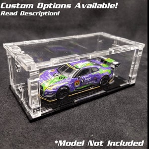 May include: A clear acrylic display case with a black base for a model car. The case has a removable lid and is designed to protect and showcase a model car. The text "*Model Not Included" is printed on the base of the case.