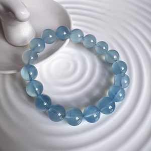 Könnte beinhalten: Ein hellblaues Edelstein-Armband mit runden Perlen. Das Armband besteht aus natürlichen Steinen und ist perfekt für den täglichen Gebrauch.