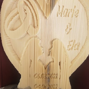 May include: A heart-shaped book sculpture made of folded paper, with the words "Marie & You" and a date inscribed on it.