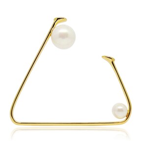 May include: Gold triangle shaped earring with two white pearls.