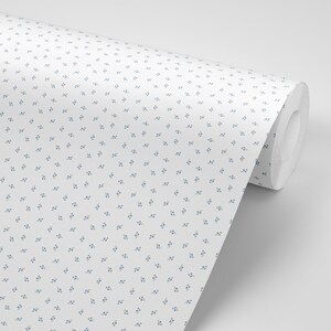 May include: A roll of white wallpaper with a repeating pattern of small blue flowers.
