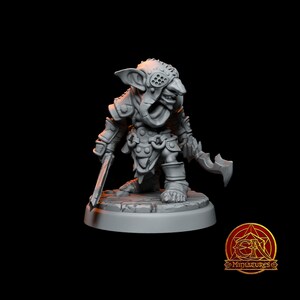 Peut inclure: Une figurine miniature grise et détaillée d'un guerrier gobelin. Le gobelin porte une armure et tient une épée et une hache. La figurine est debout sur une base ronde.