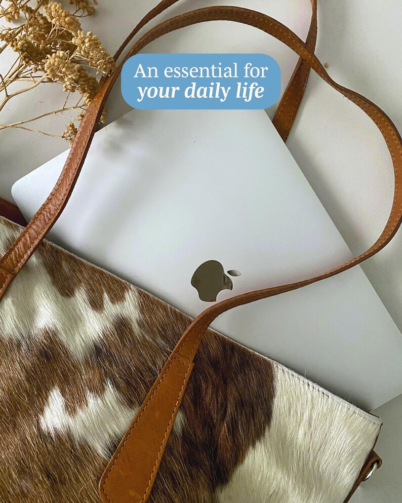 May include: A brown leather tote bag with a cowhide pattern. The bag has a white laptop inside and the text "An essential for your daily life" is superimposed on the image.