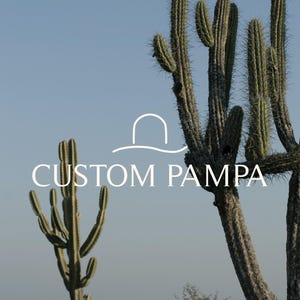 May include: A close-up of two tall cacti against a blue sky. The cacti are green and brown with sharp spines. The text "CUSTOM PAMPA" is written in white letters below the cacti.