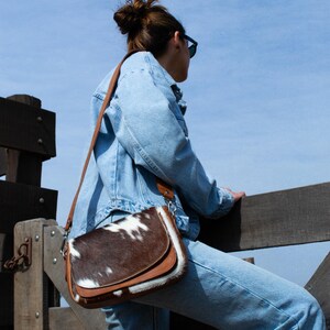 Effortless style, wherever you go. This cowhide crossbody adds a unique touch to any look.