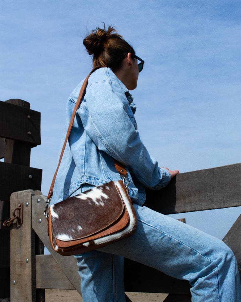 Effortless style, wherever you go. This cowhide crossbody adds a unique touch to any look.