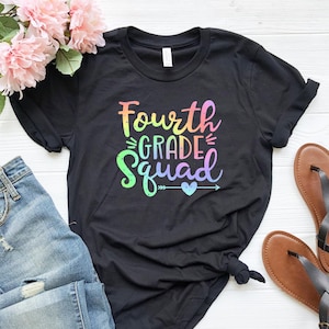 May include: Black t-shirt with a rainbow colored graphic that says "Fourth Grade Squad" with a small heart and arrow.