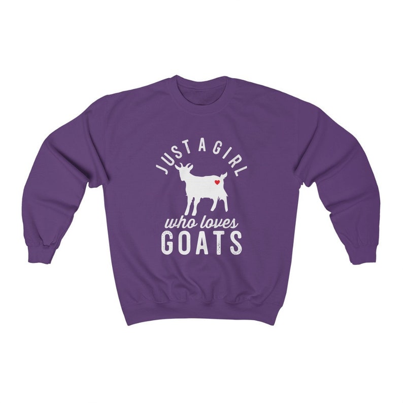 May include: Purple sweatshirt with a white silhouette of a goat with a red heart on its side. The text "Just a girl who loves goats" is printed on the sweatshirt.