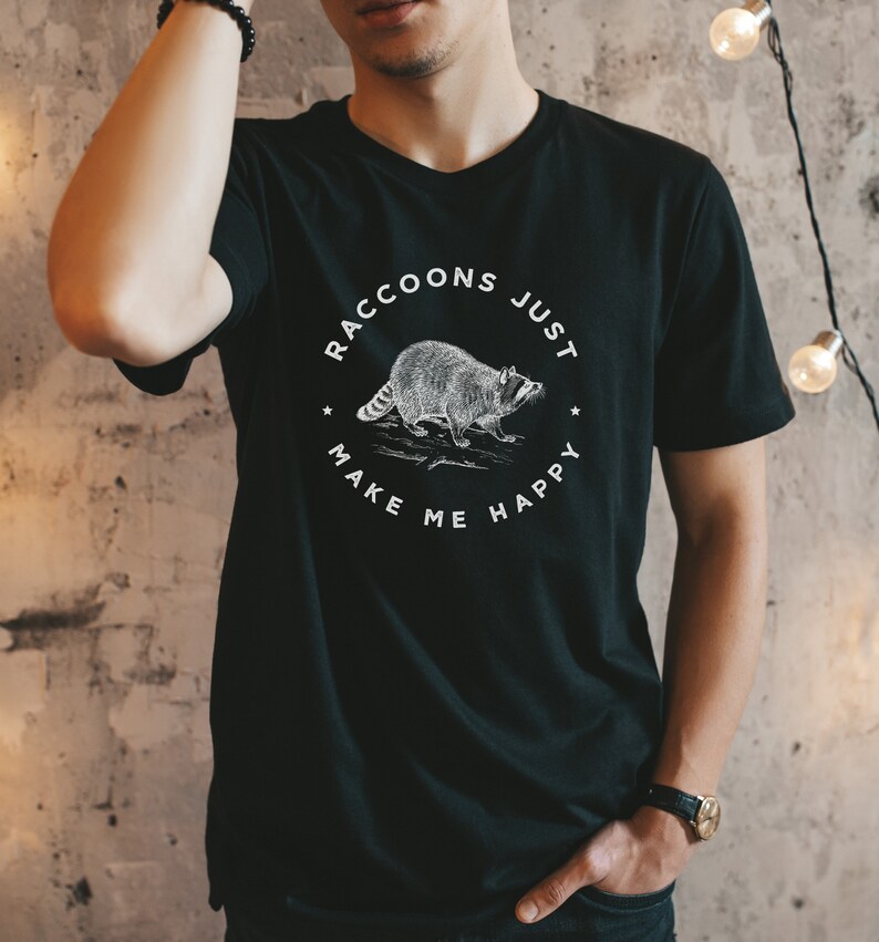 K&ouml;nnte beinhalten: Schwarzes T-Shirt mit einem wei&szlig;en Grafikdruck eines Waschb&auml;ren und dem Text "Raccoons Just Make Me Happy".