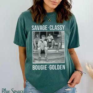 Puede incluir: Una camiseta verde azulada con una foto en blanco y negro de cuatro personas sentadas en un porche. El texto "Savage - Classy" est&aacute; por encima de la foto y "Bougie - Golden" est&aacute; por debajo de la foto.
