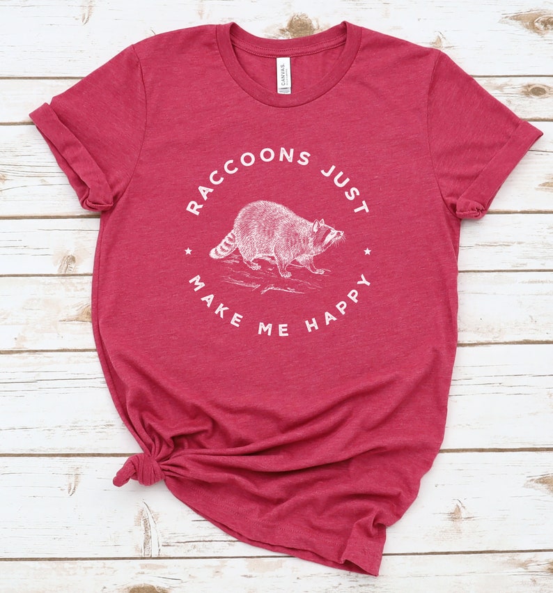 K&ouml;nnte beinhalten: Rotes T-Shirt mit einer wei&szlig;en Grafik eines Waschb&auml;ren und dem Text "Raccoons Just Make Me Happy".