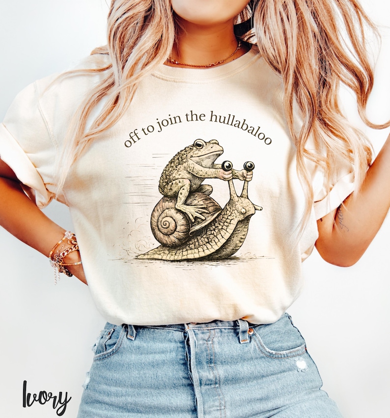 Nyckfull groda och snigel-t-shirt, iväg för att gå med i all oväsen, rolig djurt-t-shirt från Cottagecore, vintage etsad groda-tröja, mysig kaospresent Ivory