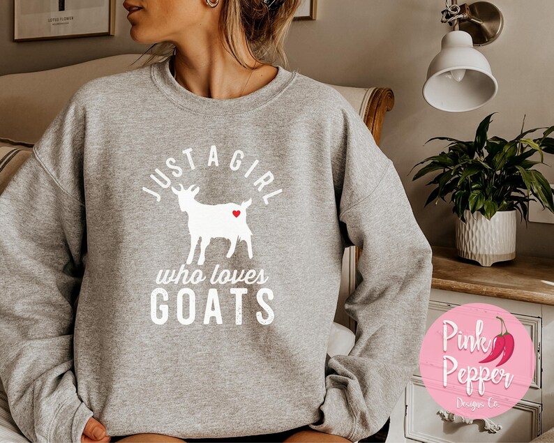 May include: Gray sweatshirt with a white graphic of a goat with a red heart and the text "Just a girl who loves goats".