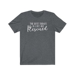 May include: A dark heather grey t-shirt with the text "The best things in life are Rescued" in white lettering with a paw print icon.