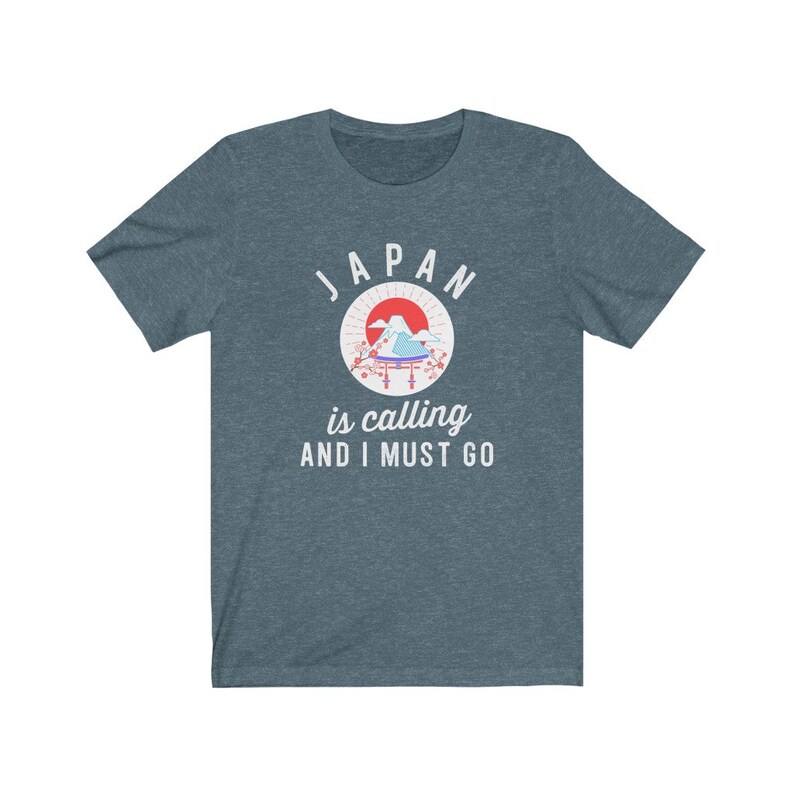 May include: A dark blue t-shirt with a white graphic of a Japanese mountain scene with a red sun and the text "JAPAN is calling AND I MUST GO".