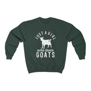 May include: A dark green sweatshirt with a white graphic of a goat with a red heart on its side. The text "Just a girl who loves goats" is printed below the goat.