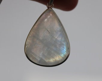 May include: A teardrop-shaped pendant with a white iridescent gemstone set in silver.