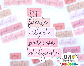 May include: Pink and peach watercolour stickers with the Spanish text "Soy fuerte valiente poderosa inteligente" (I am strong, brave, powerful, intelligent). The stickers are arranged in a stack and have a white background. The text is in a cursive font.