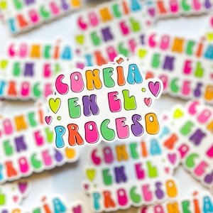 May include: A colorful sticker with the text "CONFIA EN EL PROCESO" in a rainbow font with pink hearts. The sticker is surrounded by other stickers with the same text in different colors.