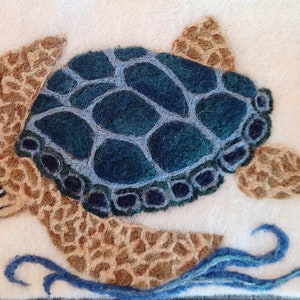 May include: A felt needle-felted sea turtle with a blue and green shell, brown body, and a brown head. The turtle is swimming in blue water.
