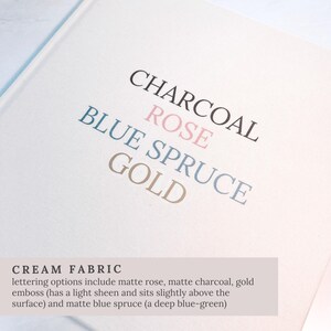May include: Cream fabric with the words CHARCOAL, ROSE, BLUE SPRUCE, and GOLD printed on it. The text is in various colors, including black, pink, blue, and gold. The bottom of the image has the text CREAM FABRIC.