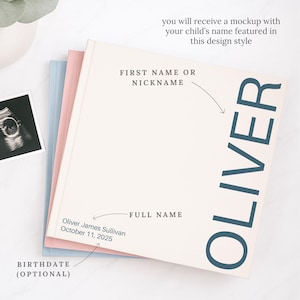 May include: A stack of three baby memory books in pastel colors. The top book is off-white with the name "OLIVER" in large, dark blue letters. Text on the book includes "FIRST NAME OR NICKNAME" and "FULL NAME". An ultrasound photo is visible.