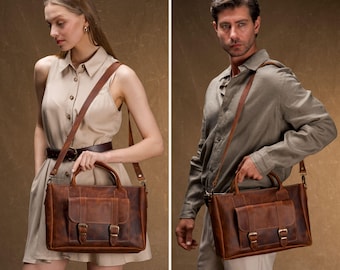 May include: Two people are shown holding brown leather briefcases with shoulder straps. The briefcases have a front pocket with two buckles and a top handle. The leather has a distressed look. The background is a solid brown color.
